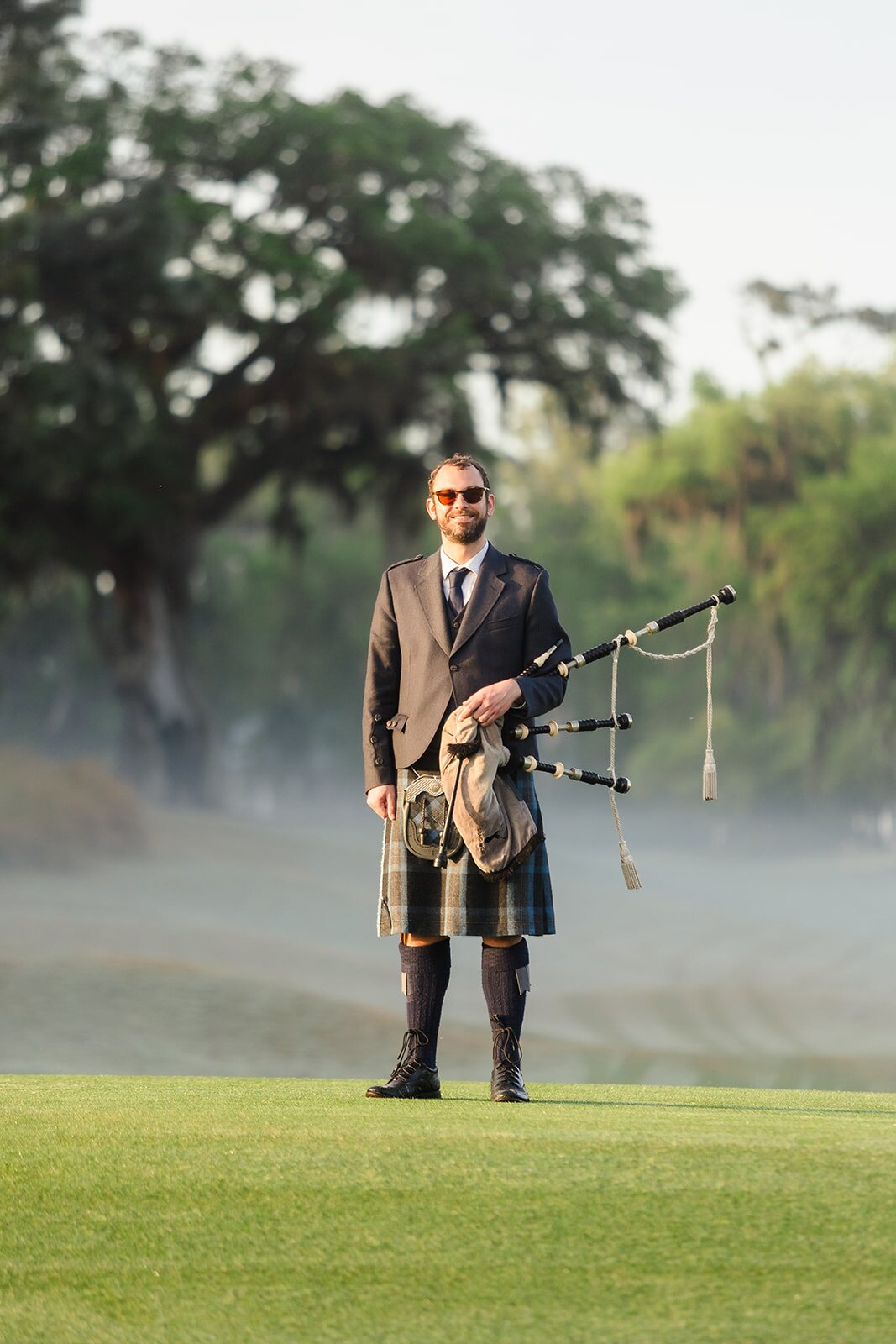 Bagpiper with golfer in the foreground at The Ford Collegiate opening