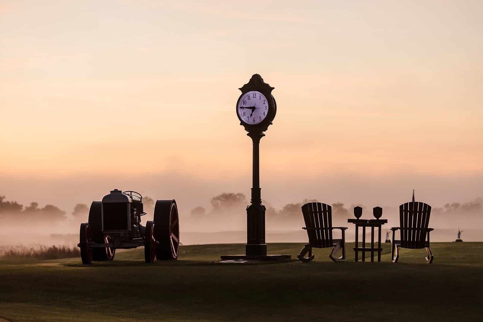 Clock and vintage Ford tractor at first light during The Ford Collegiate at The Ford Field and River Club
