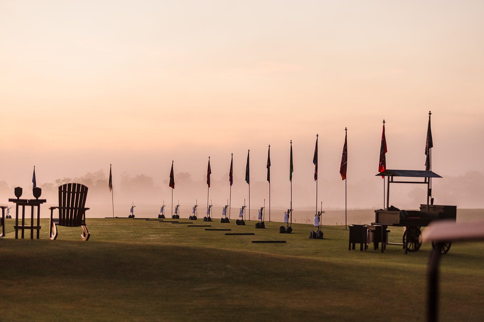 Flags lining the course at The Ford during a foggy sunrise