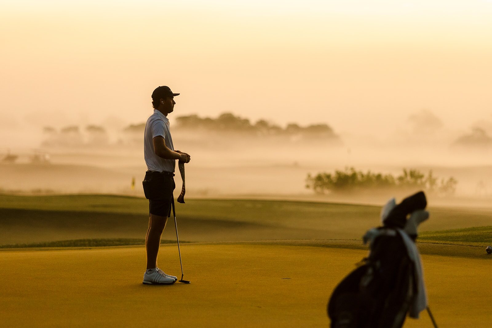 Golfer standing in warm morning haze at The Ford Collegiate