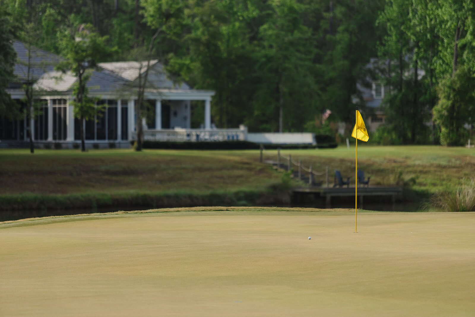 Golfer swinging with The Ford residences in the background