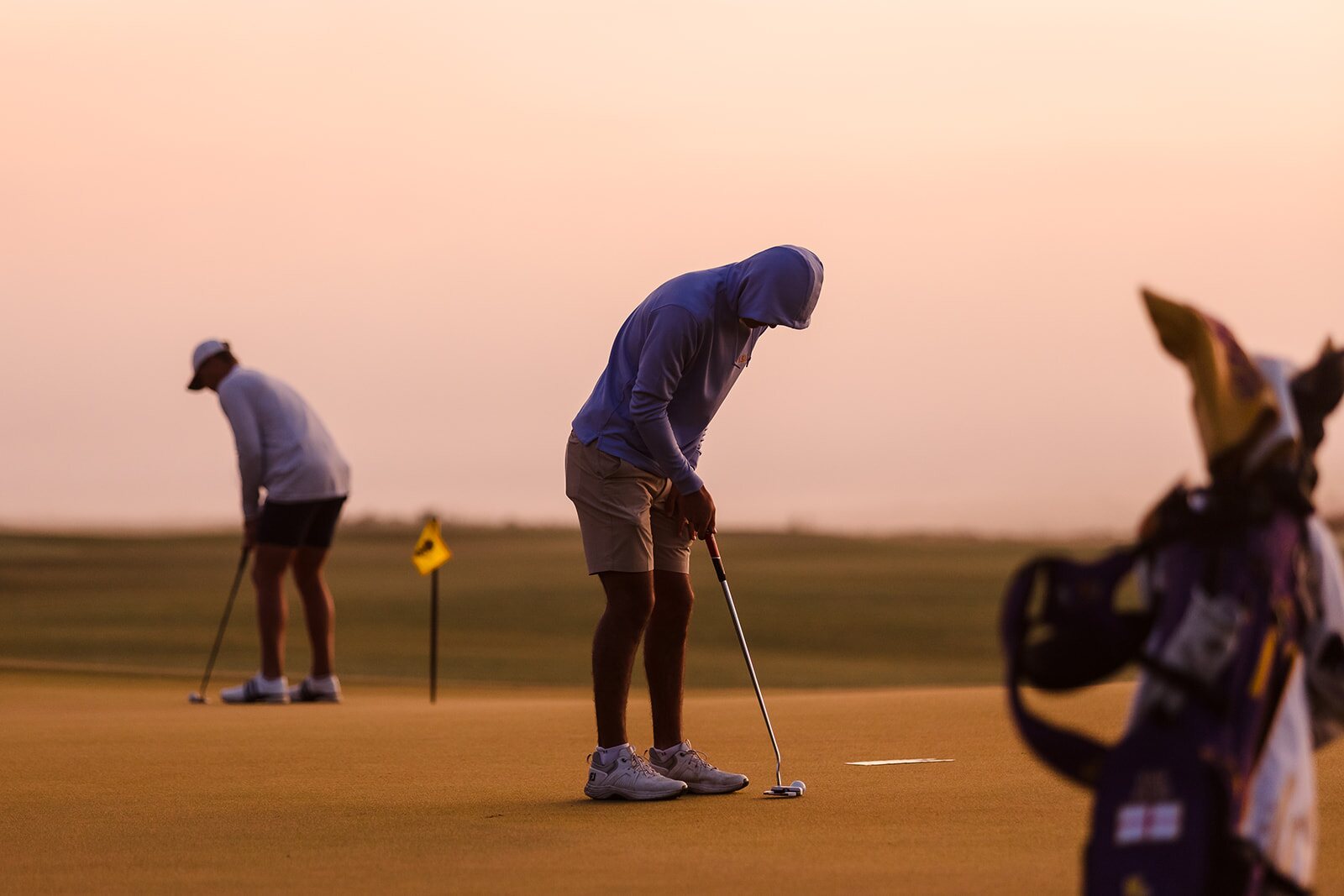 Golfer putting at sunrise during The Ford Collegiate