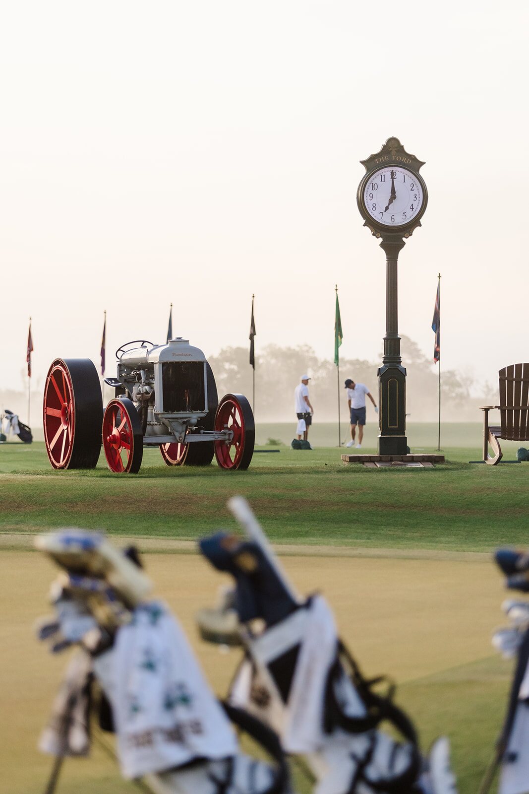 Vintage Ford tractor and course clock with golf bags in the foreground